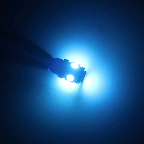 Lit Ice Blue 12V 194 W5W LED Bulb Replacement Kit glowing in the dark, showcasing bright 360° light for car interior lighting.