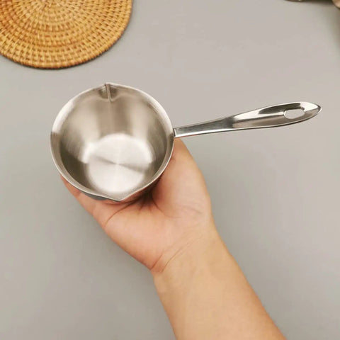 Slick Melting Pot With Pour Spout For Hot Coffee Chocolate And Soups Fire Kitchen Warmer Bowl held in hand, stainless steel material.