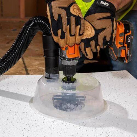 Front view of Klein Tools adjustable circle hole cutter with dust bowl and vacuum hose on drywall surface