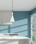 White 7.25-Inch Mini Pendant Light With Gold-Interior Metal Shade hanging in a modern kitchen, adjustable cord visible.
