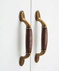 Vintage Walnut Wood Cabinet Handles Set With Zinc Alloy Drawer Pulls in Antique Metal Finish on white doors.
