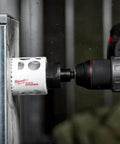 Milwaukee 4-inch ice-hardened hole saw installed on cordless drill for metal cutting