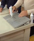 Person using Easy Clean Grout Finish Kit With Color And Seal Grout, Stain Resistant Finish With Protective Barrier, on tile surface.