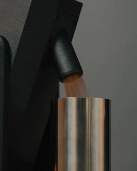 Dope Stepless Coffee Grinder Featuring 40mm Stainless Steel Conical Burrs For Pulling Consistent Espresso Shots And Brewing Smooth Daily Drips With Hella Low Retention In Matte Black pouring ground coffee into a silver hopper.