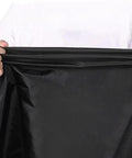 Hands holding black fabric of All Weather Treadmill Cover For Home Gym Indoor Outdoor Use Dustproof Protective Shield That Keeps Dust Moisture Off Fits Nonfoldable And Foldable Treadmill Models A And B Ideal For Any Treadmill Black