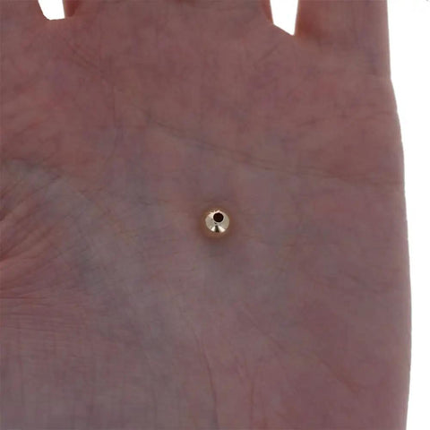 Straight Premium 6MM Gold Filled Round Beads For Jewelry Crafting, shown in hand, smooth seamless shape detail.