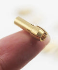 Close-up of Pro Grade Brass Collet from Pro Grade Brass Collet Set For Rotary Tools 10 Pieces Assorted Sizes 0.5mm 0.8mm 1mm 1.2mm 1.5mm High Wear Resistant Precision That Grips Bits Firmly And Keeps Stable At High Speeds Compatible With Dremel showing precise design and brass material, displayed on fingertip.