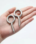 Two 304 stainless steel eye screws showcased in a hand, 2.5 inch for hanging cables or wires indoors and outdoors.