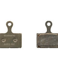 K05S-RX Resin-Coated Disc Brake Pads with Spring and Steel Backing, front and back views, for mountain and road bikes