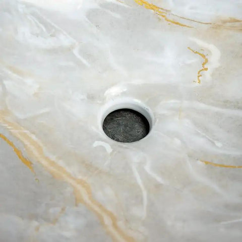 Close-up of the center drain in a Bathroom Sink Bathroom Sink Marble Ceramic Sink with elegant white and gold veining.
