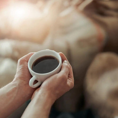 Person holding a cup of coffee, close-up, relaxing with Aqua Filter System Water Filtration Cartridge 3 Pack For Precise Tamp Espresso Machines.