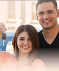 People holding car keys in front of a car with promotional stickers reading 'Discount Economical Internet Special Like New'