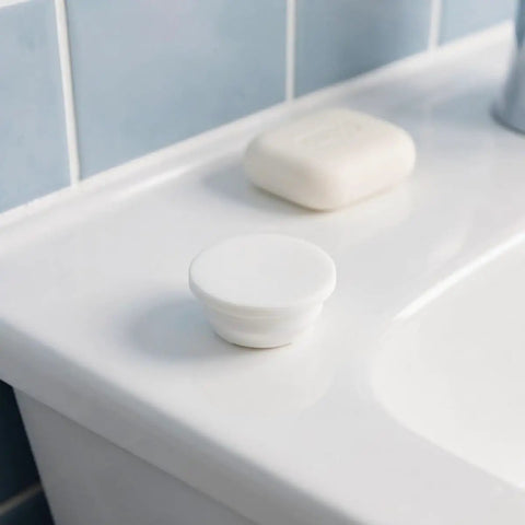 Silicone Bathtub Drain Plug Cover for 30-31mm Mounting Holes 5pcs placed on a countertop beside a soap bar.