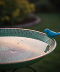Close-up of a Durable 10 Inch Standing Metal Bird Bath With Stake Outdoor Garden Feeder Bowl Vintage Green with a blue bird decoration.