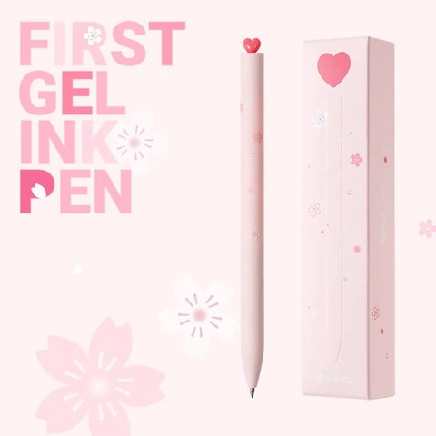 Two Pack Gel Pens With Cute Heart Design In Pink Ink Includes Four Extra Black Refills shown with packaging and pink floral decor.
