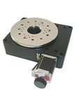 Slick High Precision Motorized Rotary Positioning Stage Delivering Buttery 360 Degree Rotation With Tight Worm Gear Mechanics And A Solid 100 Millimeter Indexing Base For Dead Center Performance, showing metal top and attached motor.