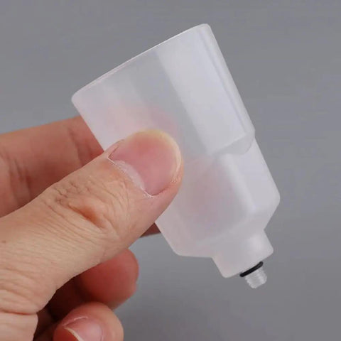 Two Pack Bike Brake Bleed Funnel With M5 Threaded Spout for Shimano Hydraulic Systems, mineral oil compatible, held in hand.