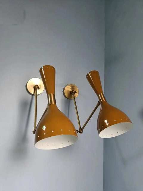 1950 Mid Century Italian Hardwire Brass Wall Sconce Pair Brown Wall Fixture Diabolo Lamp with golden shade against blue wall.
