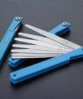 Top Shelf Feeler Gauge Set With Rock Solid Stainless Steel Blades For Nailing Dead Accurate Gap Measurements And Tappet Valve Adjustments On Every Hardcore Hobbyist Or Weekend Mechanic Garage Project, stainless steel blades with blue handles.