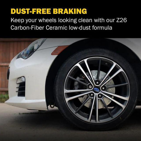 PowerStop Z26 carbon-fiber ceramic front brake pads installed on a white car with alloy wheel and visible rotor