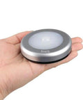Hand holding 3 Pack Motion Sensor LED Night Lights Indoor Magnetic Stick On Battery Powered Under Cabinet Lighting