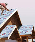Worker installing Heavy Duty Synthetic Roof Underlayment Four By Two Hundred Fifty Foot Roll on a steep roof for weather protection.