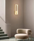 Super Tight 16W Gold LED Wall Sconce With Dimmable Rectangle Frame And Switchable Warm Natural White Glow To Honestly Level Up Your Bedroom Or Living Room Setup With Zero Fuss At All mounted next to stylish chair in modern interior.