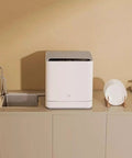 No Hookup Countertop Dishwasher That Sets Up In Minutes And Cranks Out Immaculate Loads Daily While Serving Up Sparkling Results With Fast High Temperature Wash And Dry Cycle on kitchen counter next to clean plates.