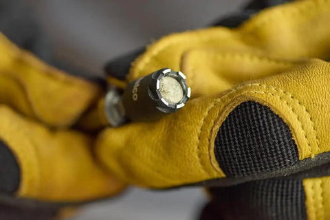 Close-up of Reversible Hex Driver With 1/4 And 5/16 In Sockets, Sawtooth Sealant Cutter for easy fastener removal, black finish.