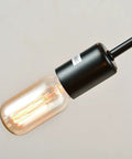 Close-up view of bulb on Vintage Metal Sputnik Chandelier With 18 Dimmable Lights In Black Finish, showing filament and black fixture.