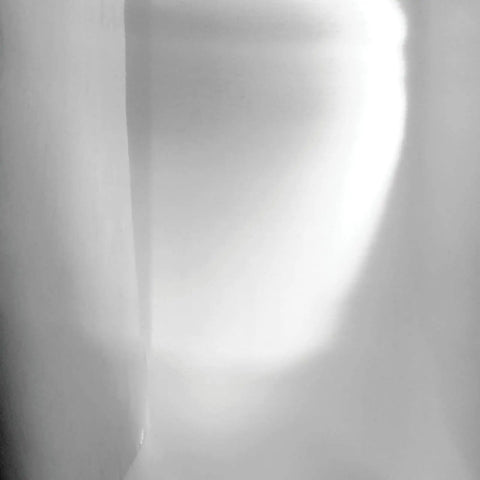 Abstract light and shadow on a wall, showcasing a soft, atmospheric gradient effect.