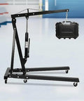 Heavy Duty Folding Engine Crane, 2 Ton Hydraulic Shop Cherry Picker lifting a black case, durable carbon steel, portable design.