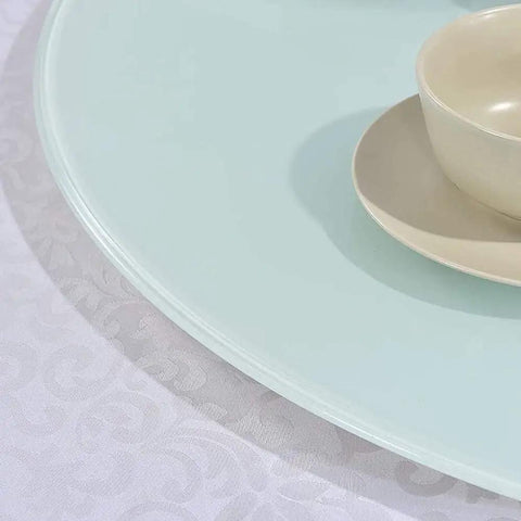 Close-up of Go To Kitchen Must Have Large Lazy Susan Serving Turntable With Glass Top showing edge detail on white tablecloth.