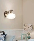 Smooth Modern Wall Sconce With White Glass Shade And Heavy Duty Metal Geometric Design For Kitchen Bedroom Hallway mounted on a wall.