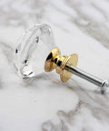 Single knob from 8 Pack Crystal Glass Cabinet Knobs With Gold Base Diamond Style Drawer Pulls, side view on marble surface.
