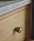Six Pack Antique Brass Cabinet Knobs With Fluted Trumpet Ends installed on wood kitchen drawer