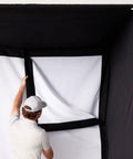 Person assembling enclosure of All In One Home Golf Sim Studio Bundle With Launch Monitor Enclosure Screen 5x5 Hitting Mat ZW350ST Projector