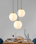 Modern Minimalist Pendant Light With White Glass Globe Shade, Premium Brass Spherical Ceiling Fixture over dining table