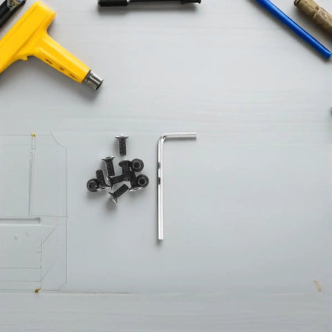 Electric Scooter Front Shock Absorber Screws Kit with Allen Wrench and scattered screws on a workbench.