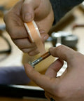 Person using Tank Bond Thread Stopper Tape Orange for interior and exterior loose screws, shown wrapping tape around a bolt.