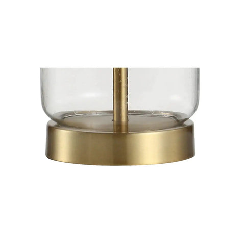 Close-up of the clear glass base with brass finish from Brass Gold And Clear Glass Table Lamp With White Linen Drum Shade.
