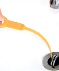 Orange drain hair snake clog remover tool being used in bathroom sink