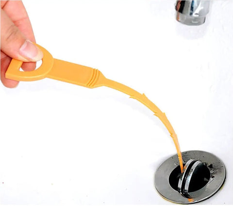 Orange drain hair snake clog remover tool being used in bathroom sink