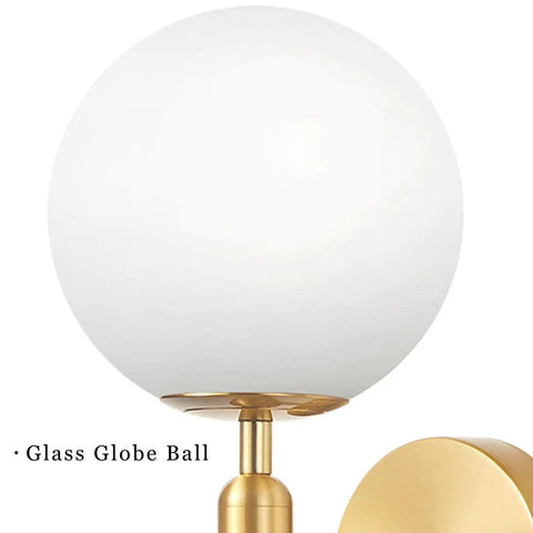 Gold Glass Globe Wall Sconce Light With Mid Century Vibe Indoor Wall Mounted Lamp showing gold base and white globe close-up.