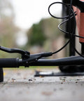 Close-up of Flipstand Compact Bike Stand with handlebar stabilizers, demonstrating its use for repairs on a bike, outdoor setting.
