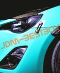 Close-up of car front with Orange Quick Release Fasteners Kit For Cars With 6061 T6 Aluminum Construction And Powder Coated Finish