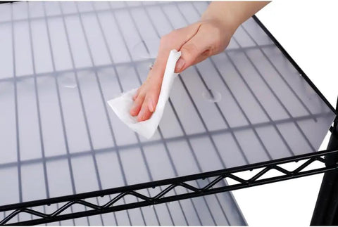Person cleaning the waterproof shelf mat of a Heavy Duty Seven Tier Wire Shelving Rack Delivering A Ridiculous 2450 Pound Weight Capacity And Rock Solid Metal Construction For Garage Storage Setup.