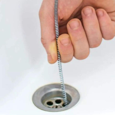 Hand using Pro Grade 10 Foot Metal Drain Cleaner and Clog Remover with Flexible Drain Snake in a sink drain.