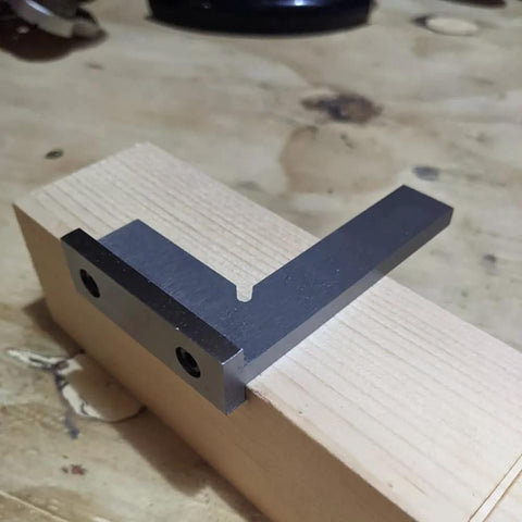 4-inch precision machinist square in gray steel with seat, 90-degree right angle on wood block