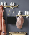 Slick Wall Mounted Hooks For Coats Keys Hats And Towels Housing A Rad Bird Motif in entryway with pink coat and cap.